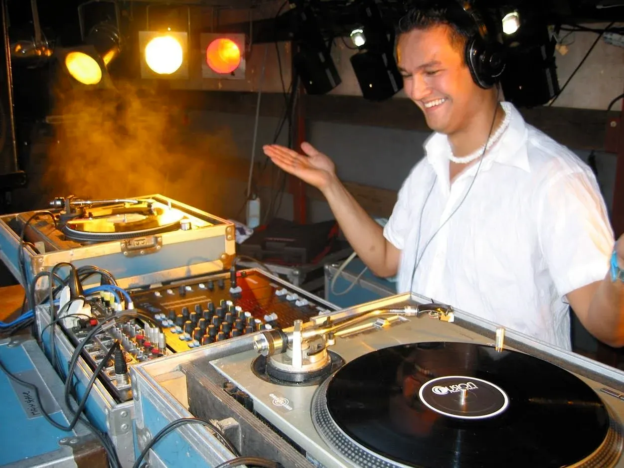 Stefan lacht achter de draaitafels in een dj-booth