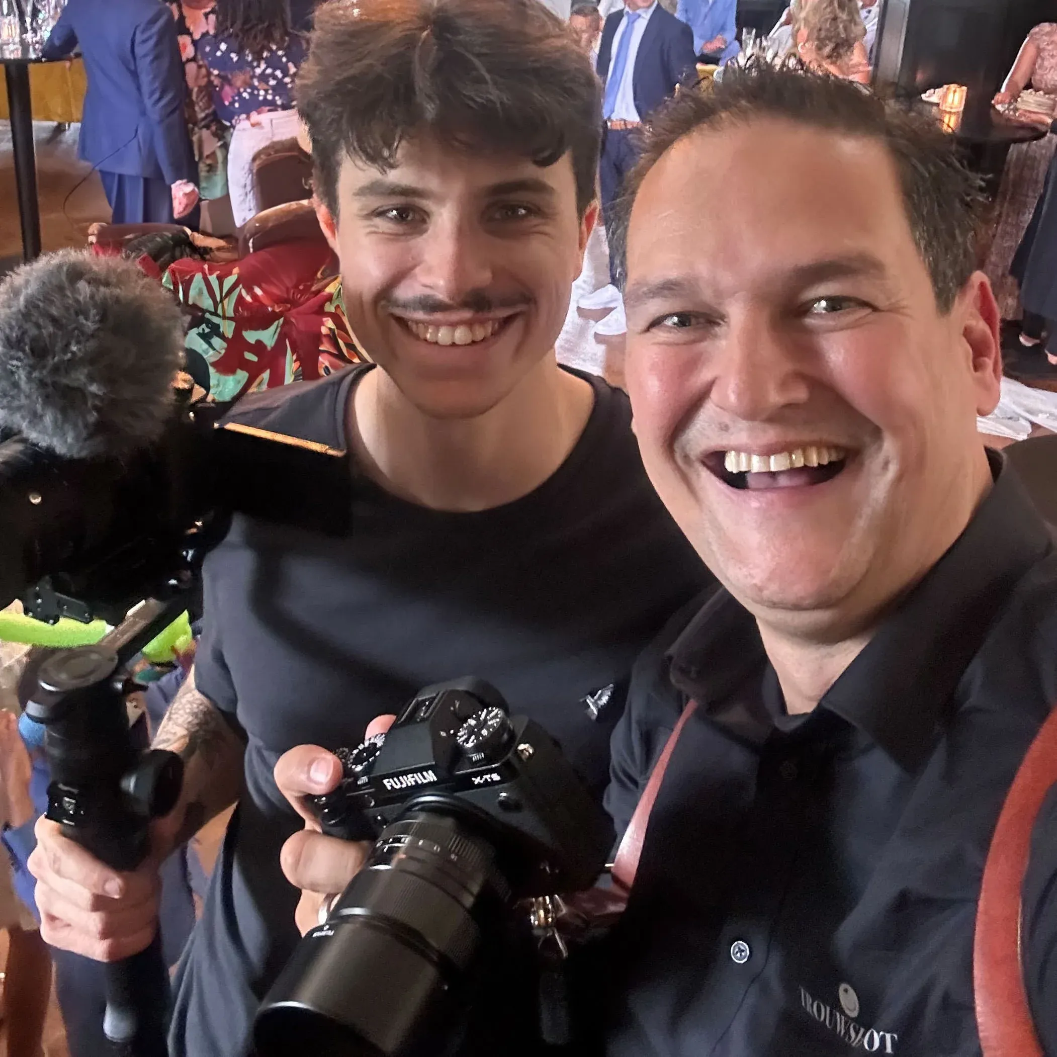 Tomas en Stefan lachend met hun camera’s op een bruiloft