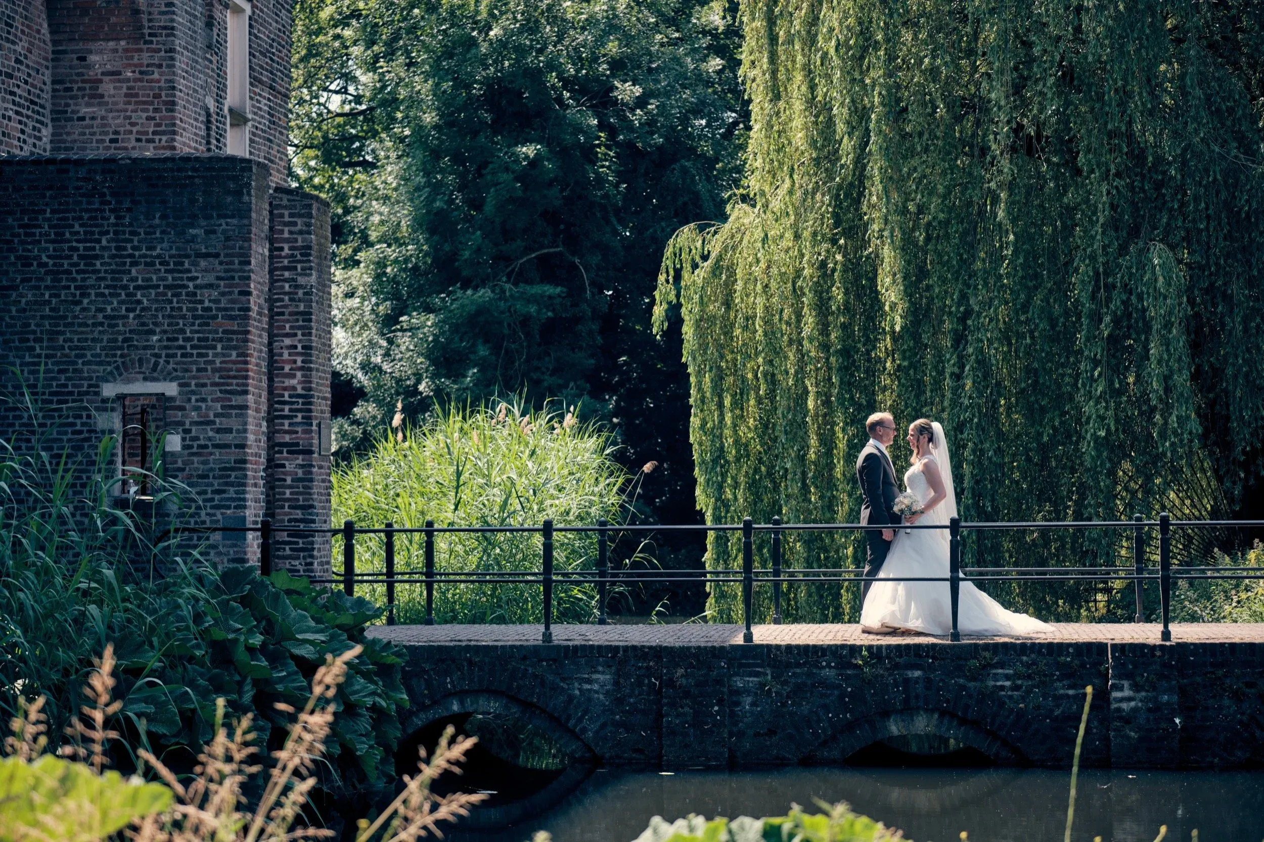 Bruidspaar op het bruggetje bij Kasteel Deurne, onder een treurwilg