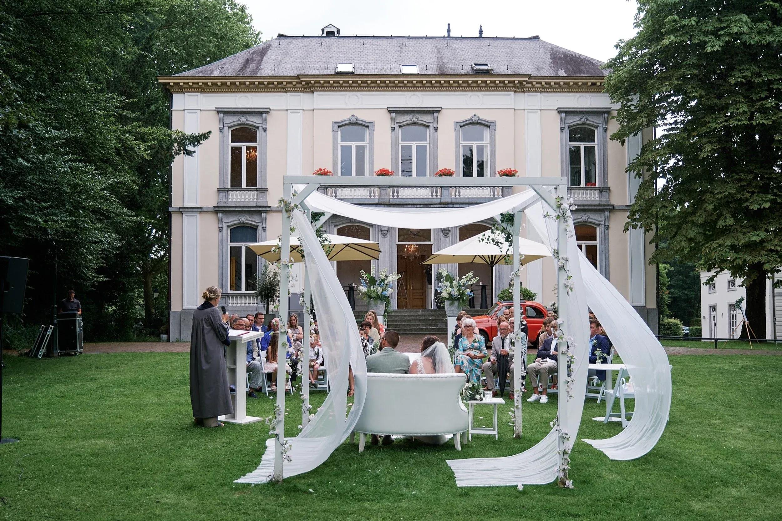 De ceremonie van Romana en Sander in de tuin voor het landhuis van Wolfslaar