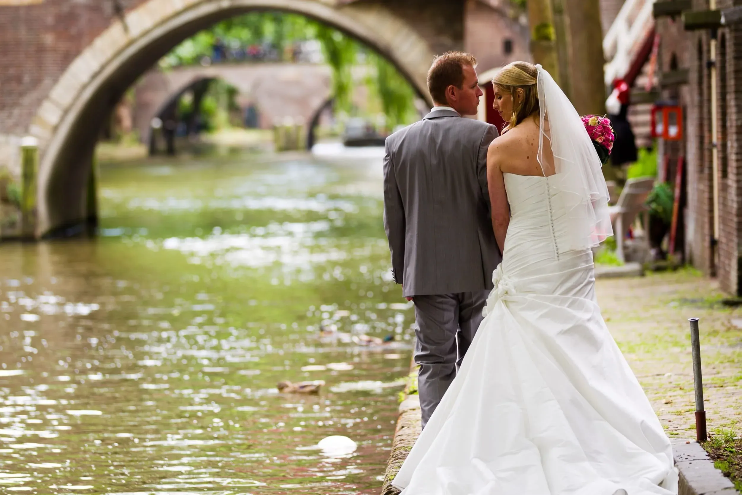 Bruidspaar aan de Oudegracht in Utrecht, met een brug op de achtergrond