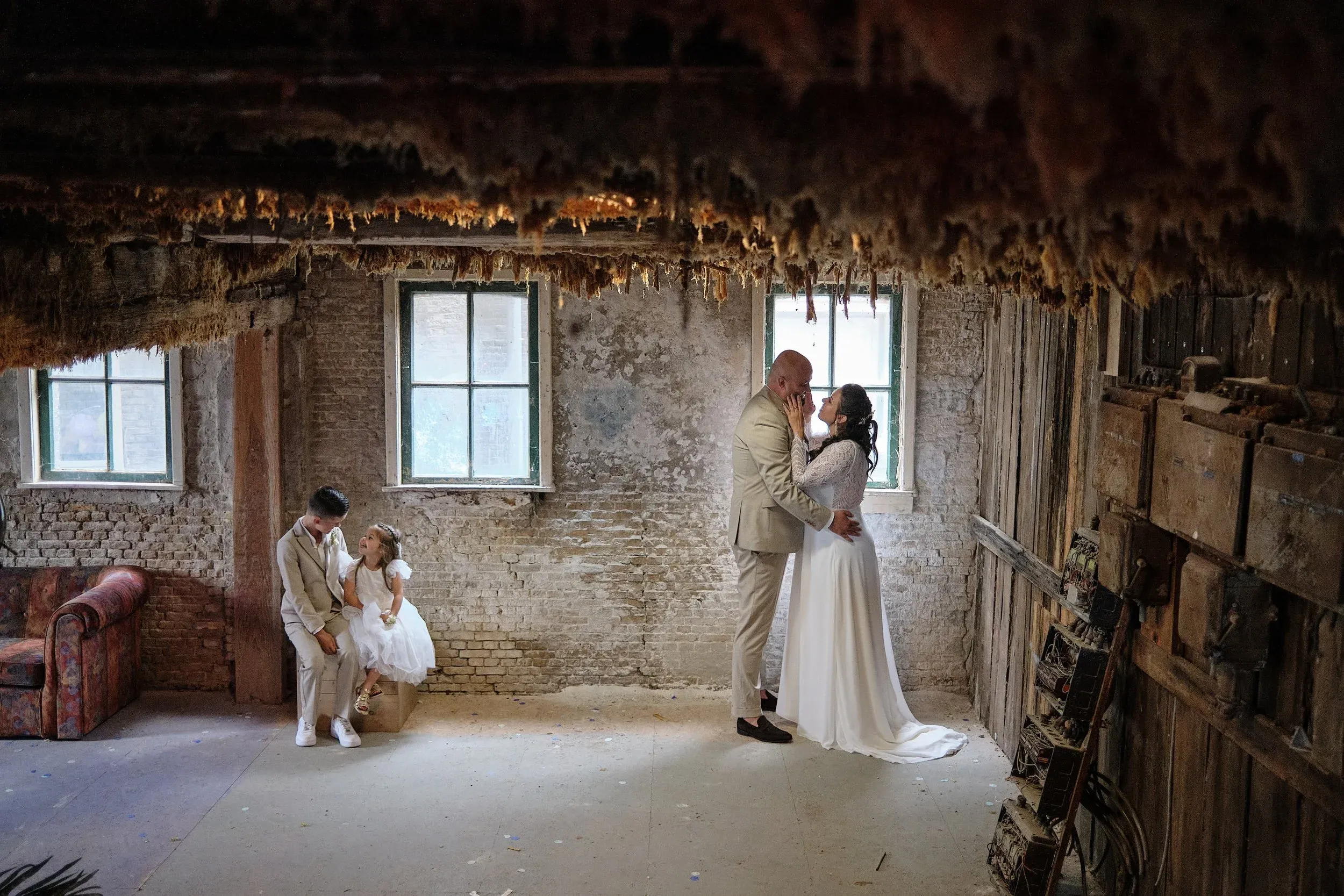 Regina en Michael bij het raam van een oude fabriekshal in de Sodafabriek in Schiedam, met hun zoon en dochter links in beeld
