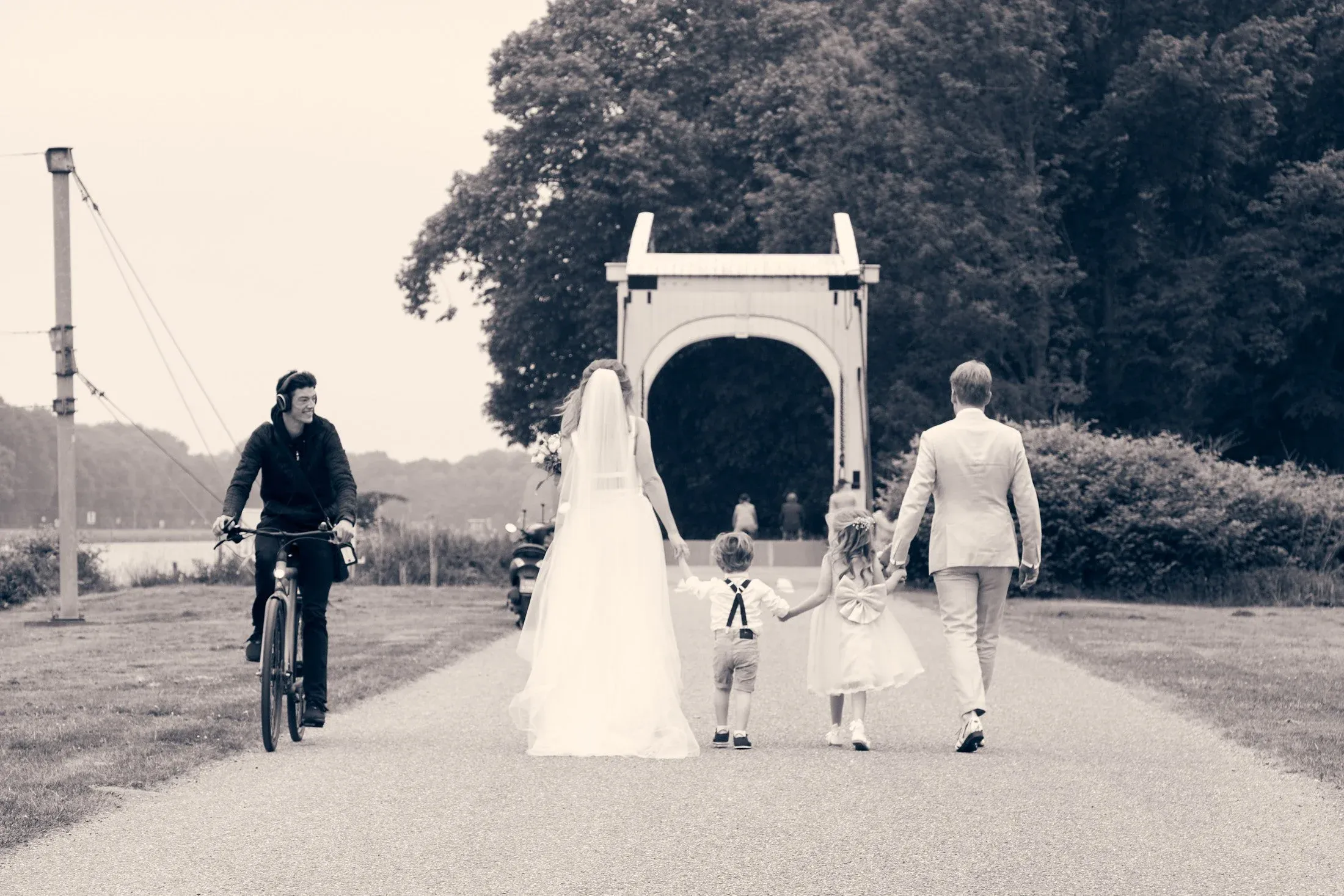 Mary en Jasper lopen met hun kinderen naar een witte ophaalbrug in het Amsterdamse Bos