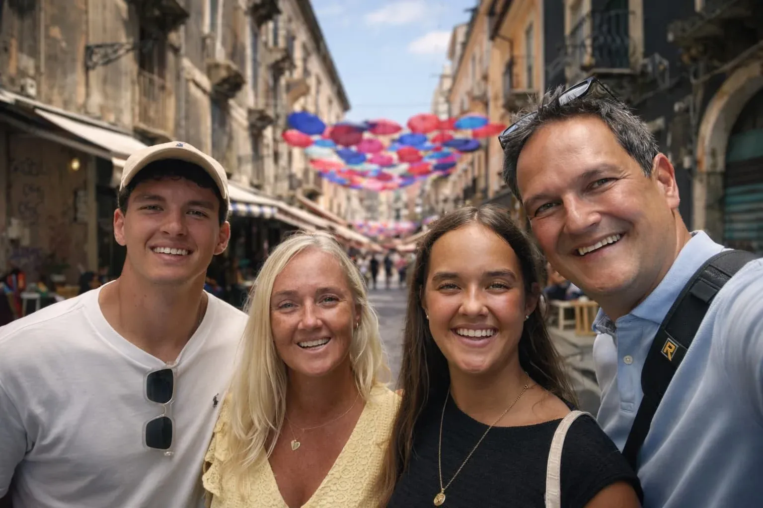 Stefan maakt een selfie met zijn vrouw en kinderen in een straat met kleurrijke parasols