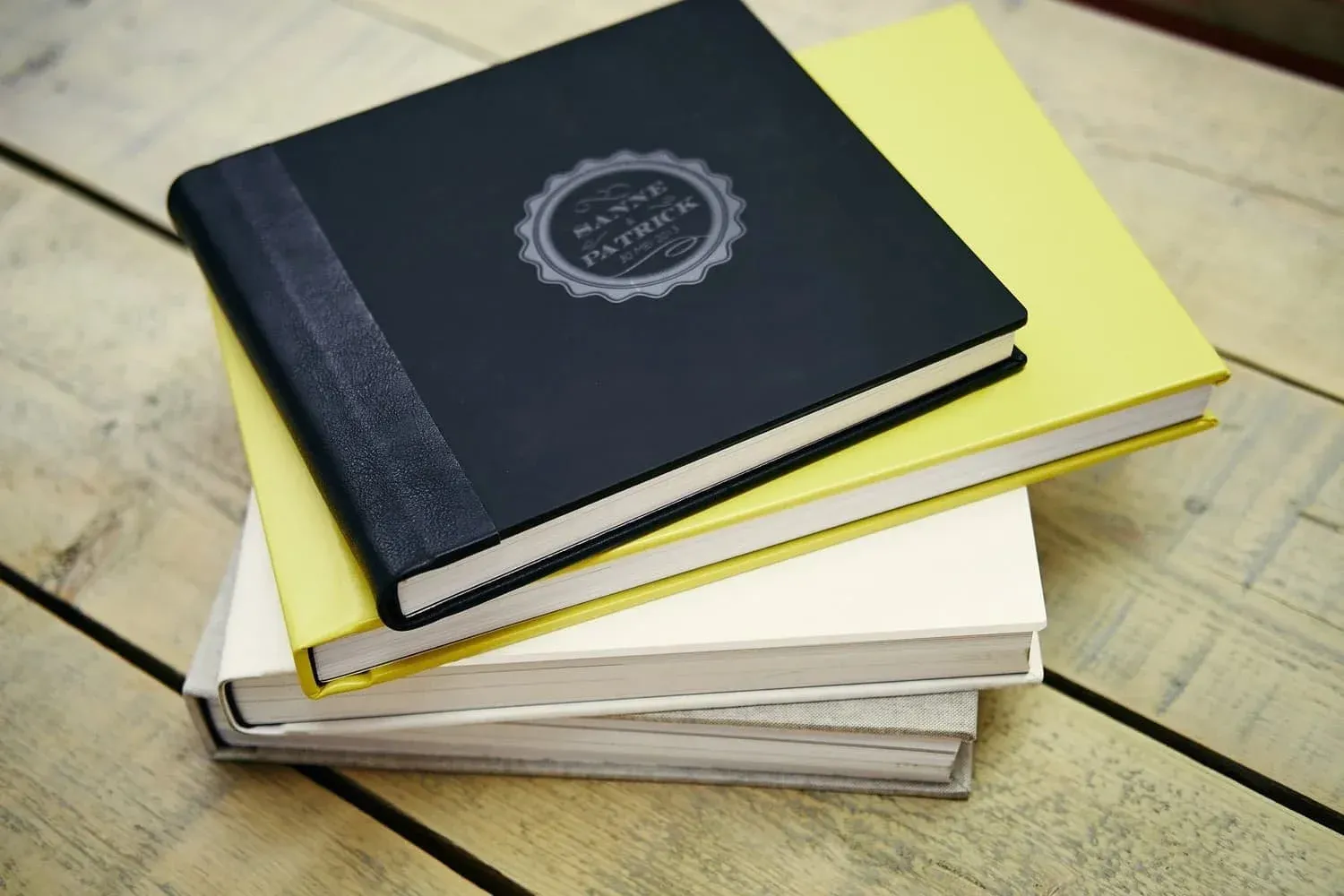 Stapel albums met covers in zwart, geel, wit en beige