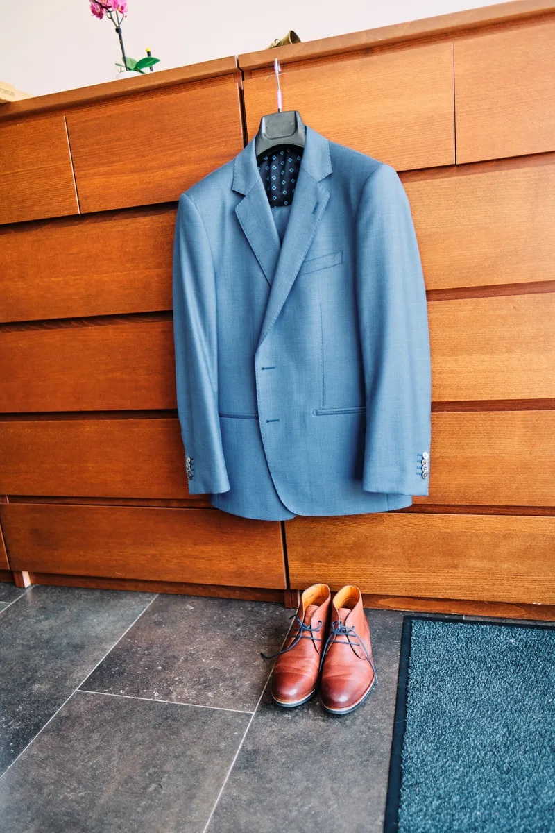Het blauwe colbert aan de kast, de schoenen eronder