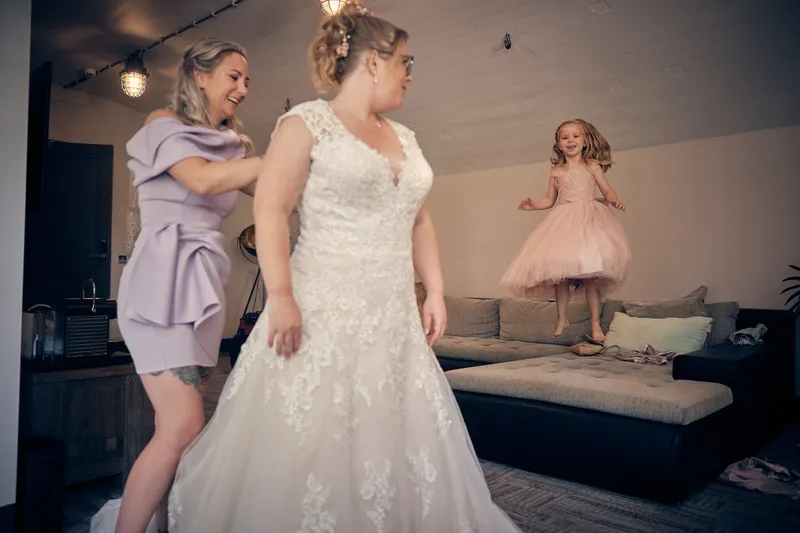 Angelique in haar trouwjurk, de jurk wordt dichtgemaakt