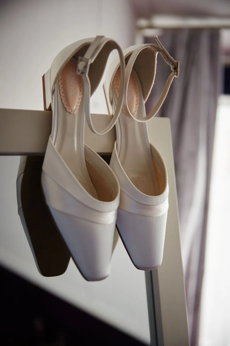 De bruidsschoenen aan een hanger