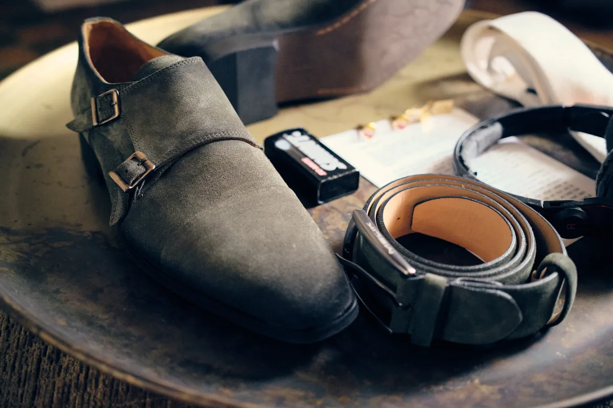 De schoenen, de riem en het horloge van Fabian op een ronde tafel