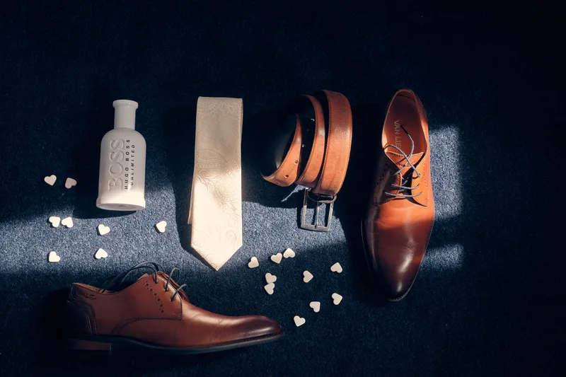 Het pak, de stropdas, riem en schoenen van Robin op een donkere ondergrond
