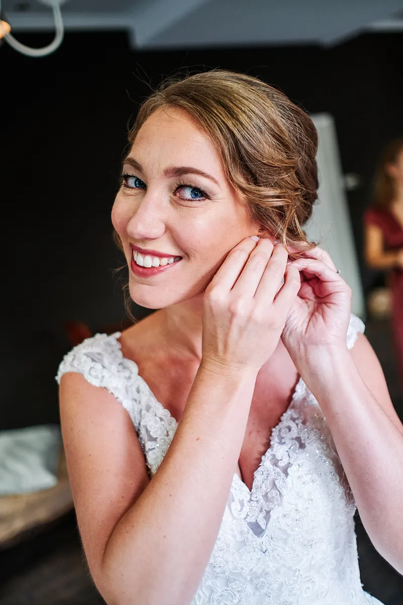 Kirsten lacht terwijl ze haar oorbel indoet