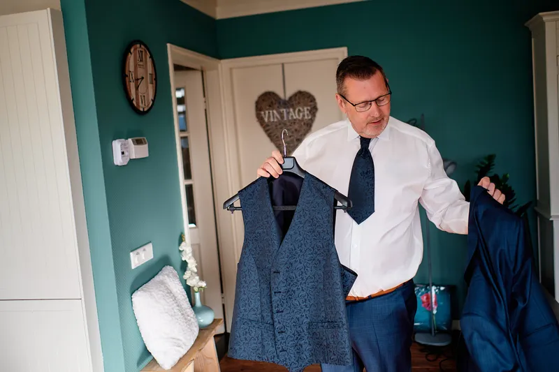 Jakob houdt zijn vest omhoog in de woonkamer