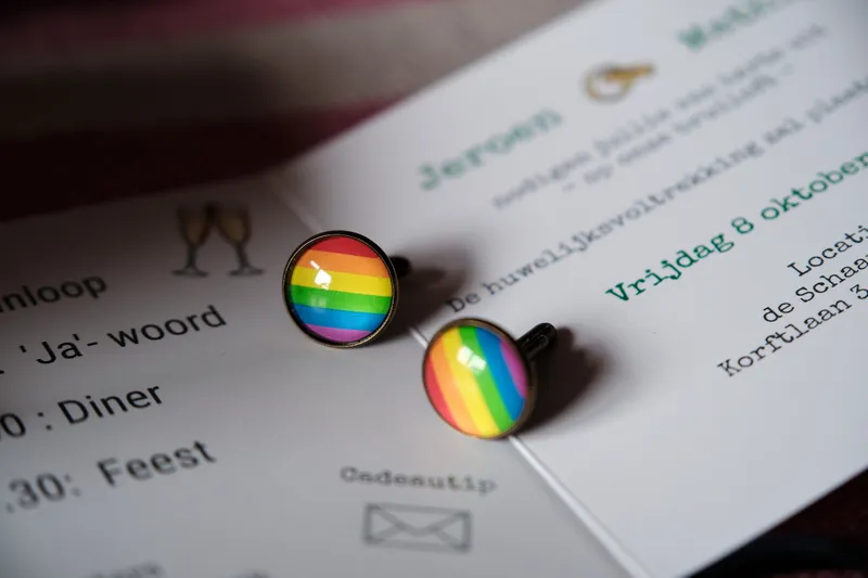 Het programma van de dag met twee regenboogspeldjes
