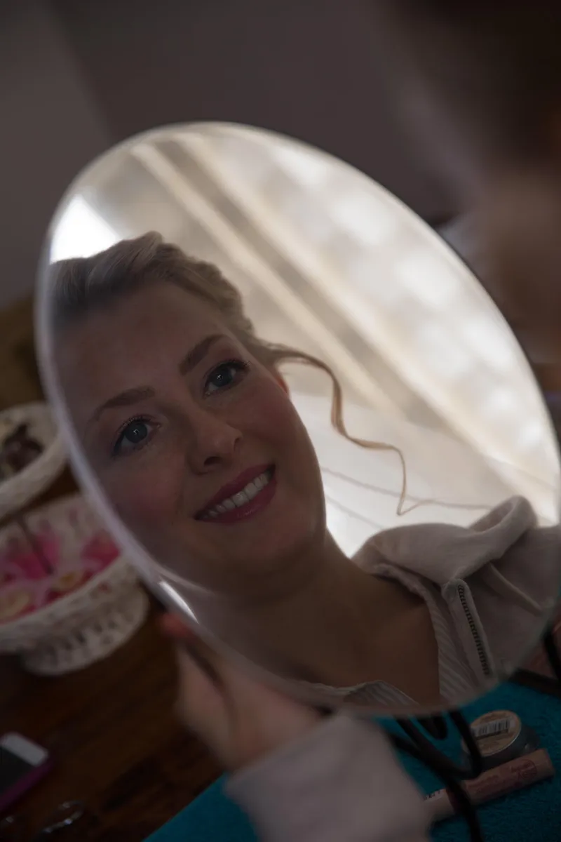 Danielle lacht in een handspiegel
