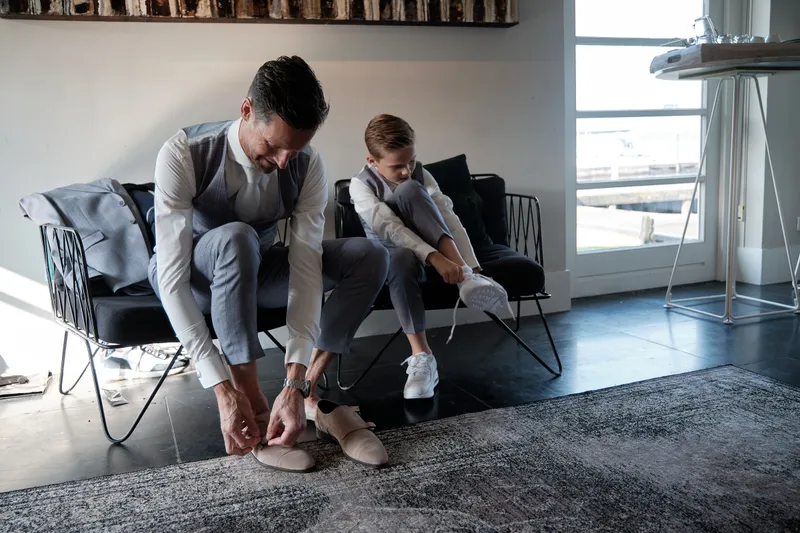 Carlo helpt een jongen met zijn schoenen
