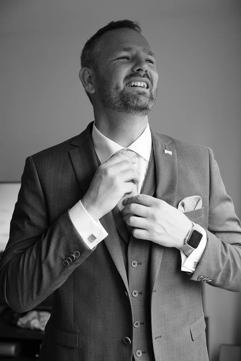 Eric lacht terwijl hij zijn manchet dichtdoet