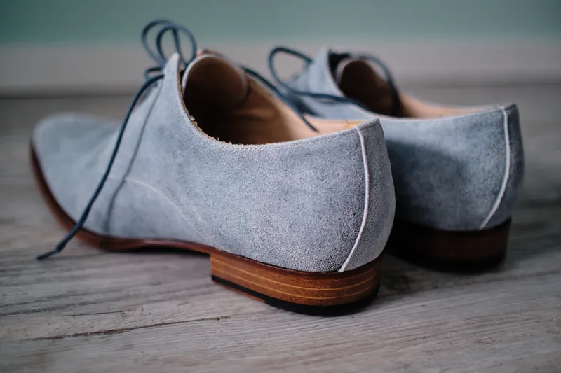 Grijze suède schoenen op de houten vloer
