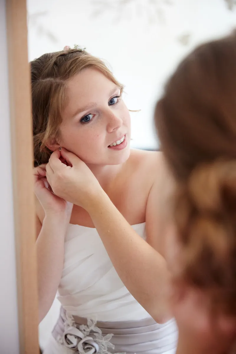 Linsey doet haar oorbel in en kijkt over haar schouder