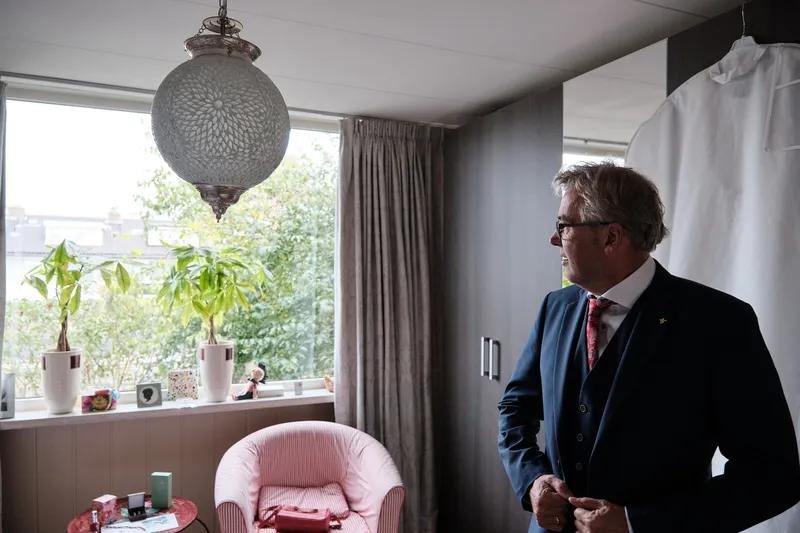 Pim in zijn pak bij het raam