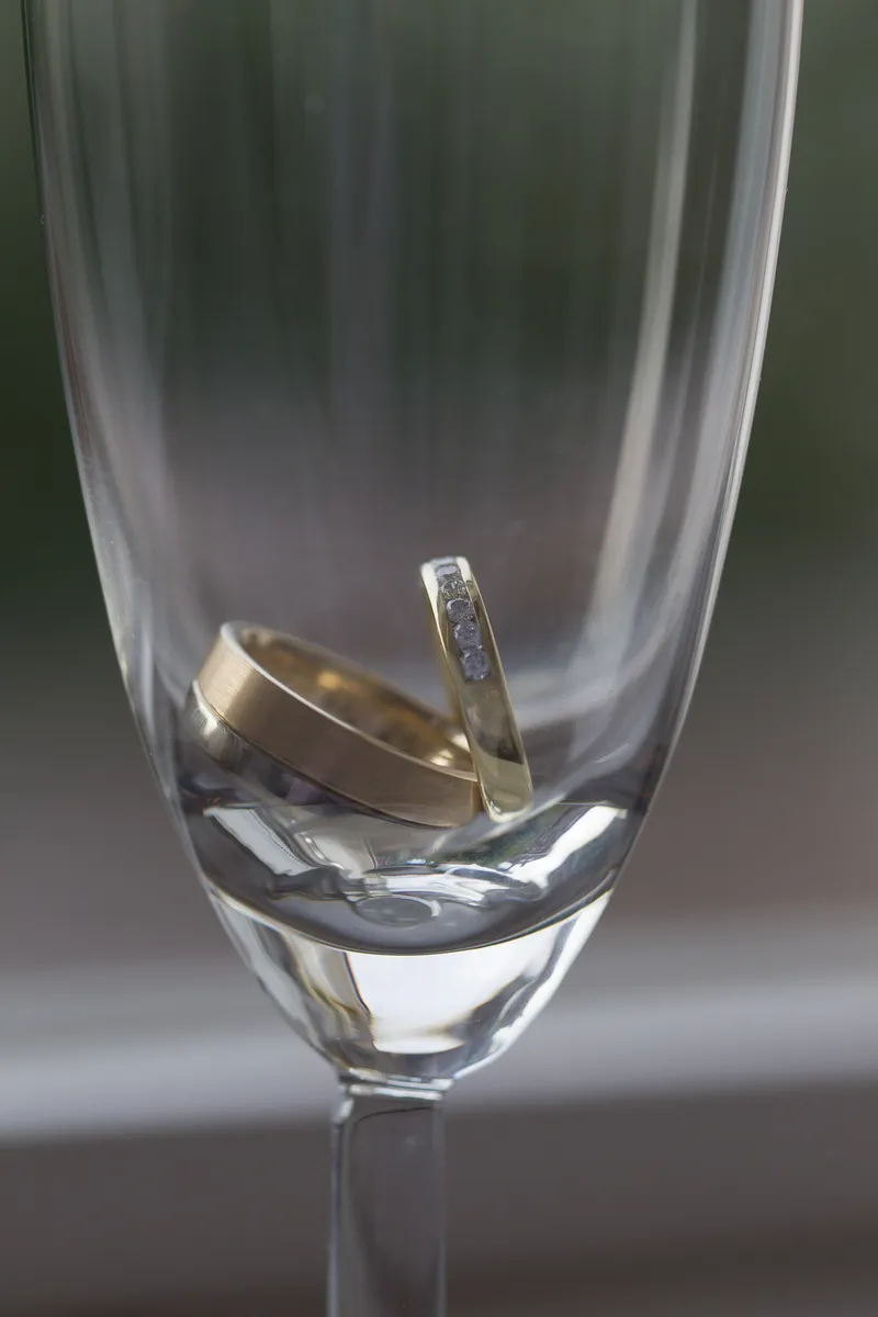 De trouwringen in een champagneglas