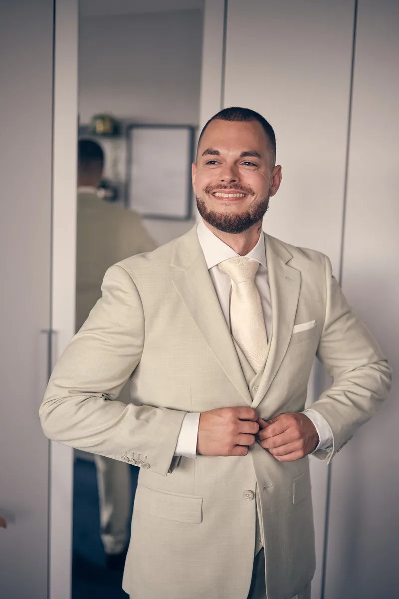 Robin knoopt lachend zijn colbert dicht