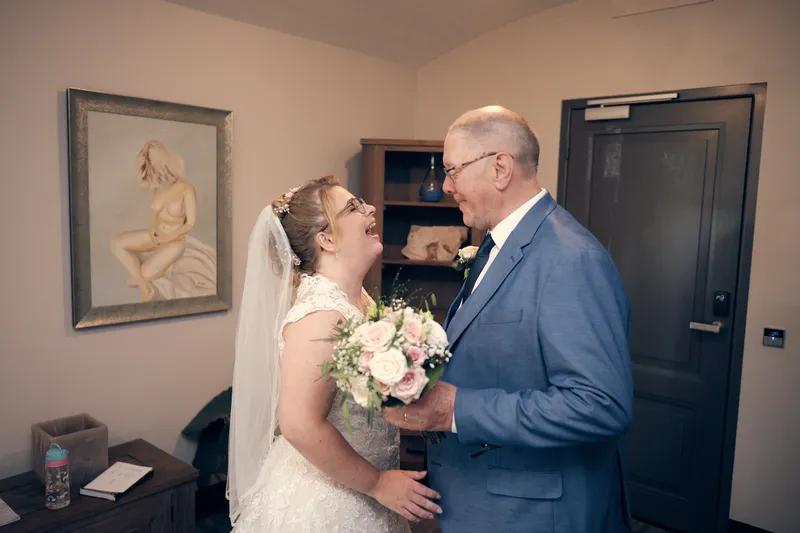 Angelique en haar vader kijken elkaar aan voor de ceremonie