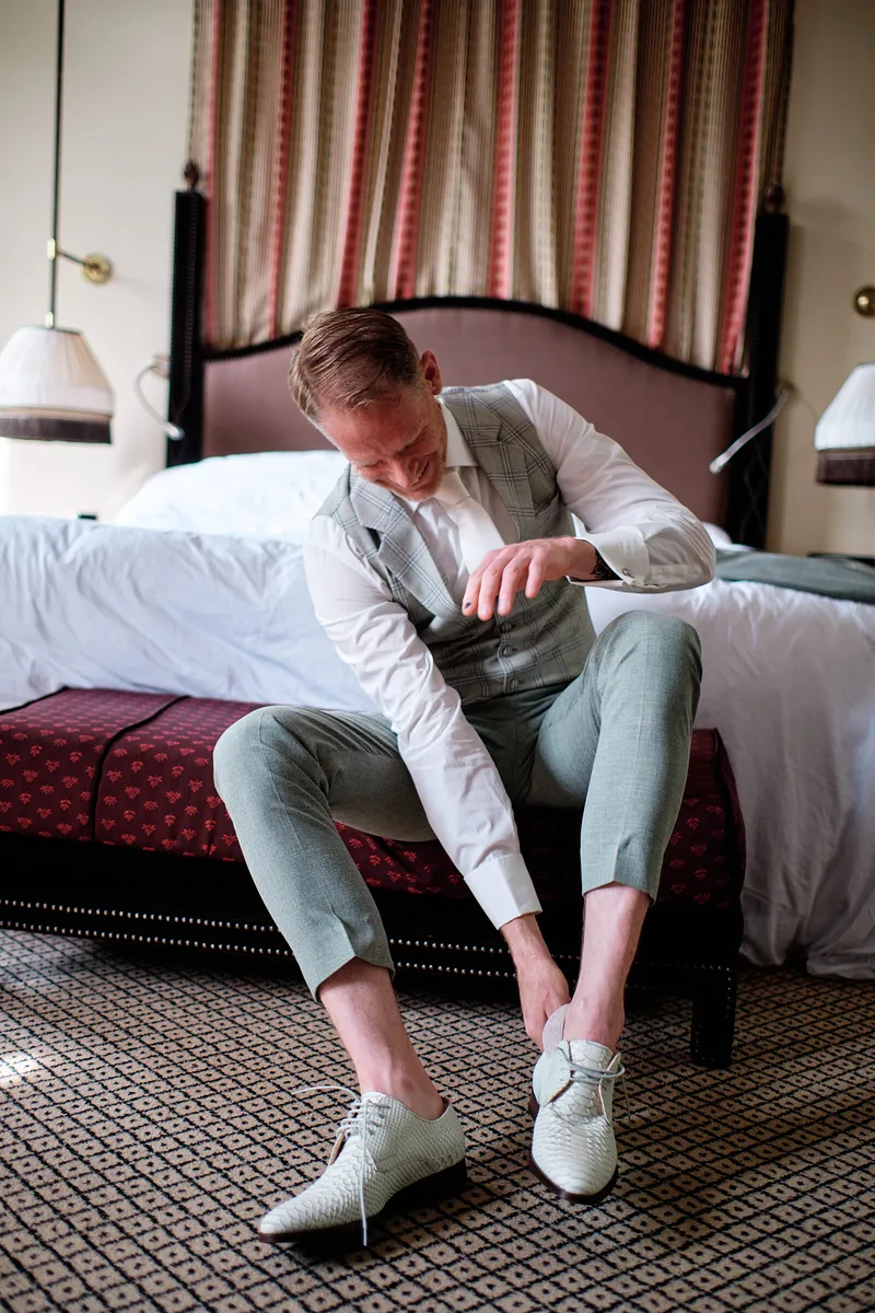 Michael trekt op het bed zijn witte schoenen aan