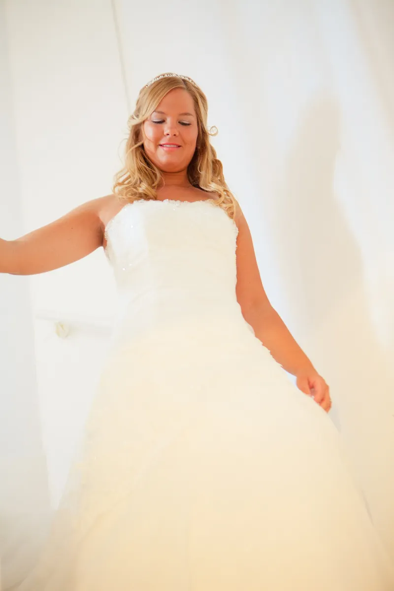 Esther in haar trouwjurk bij het raam