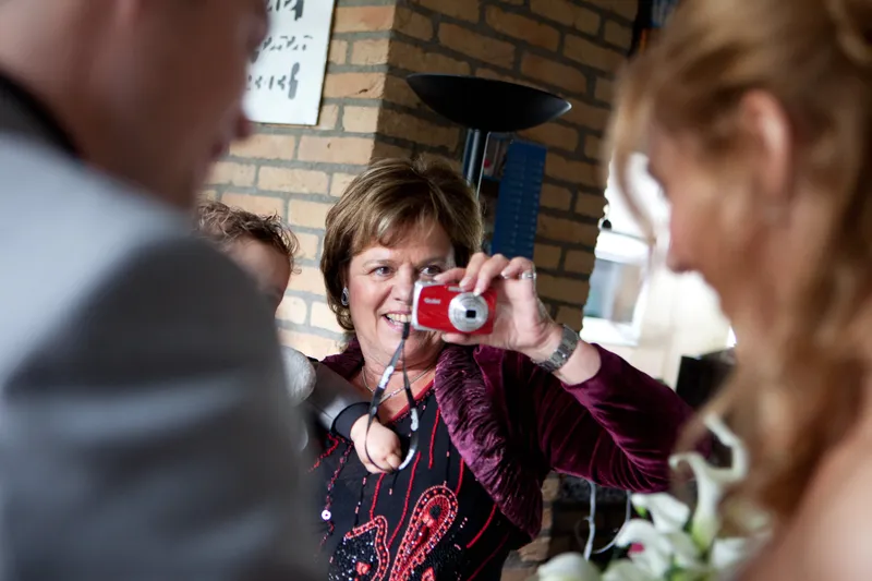 Een gast fotografeert mee achter Inge