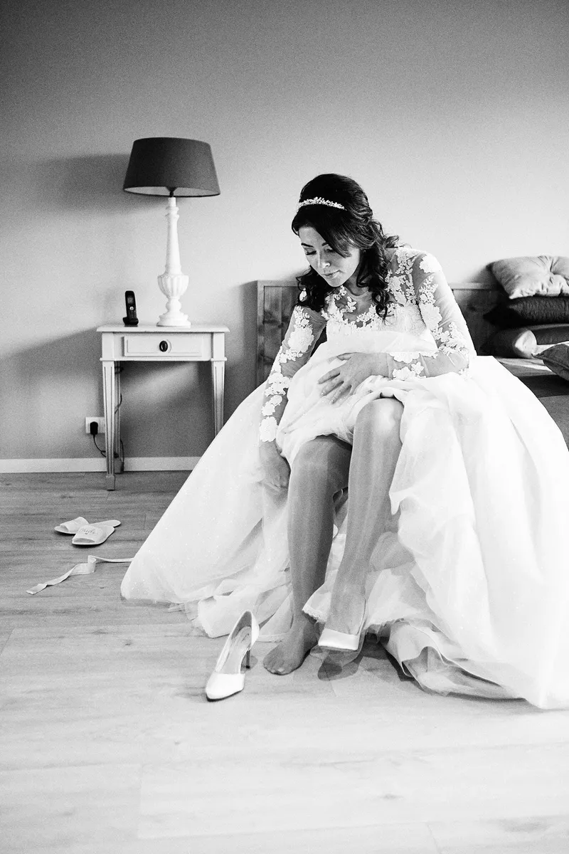 Kimberley trekt op het bed haar schoenen aan