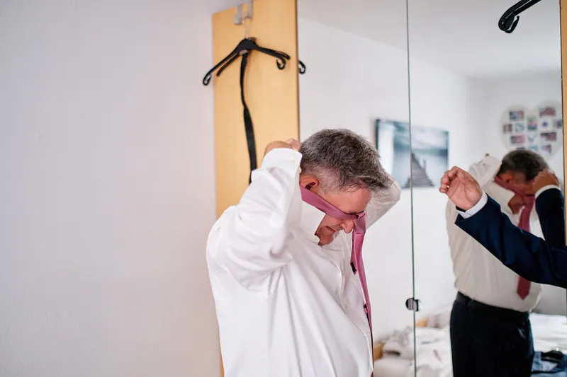 Burt trekt zijn roze stropdas over zijn hoofd