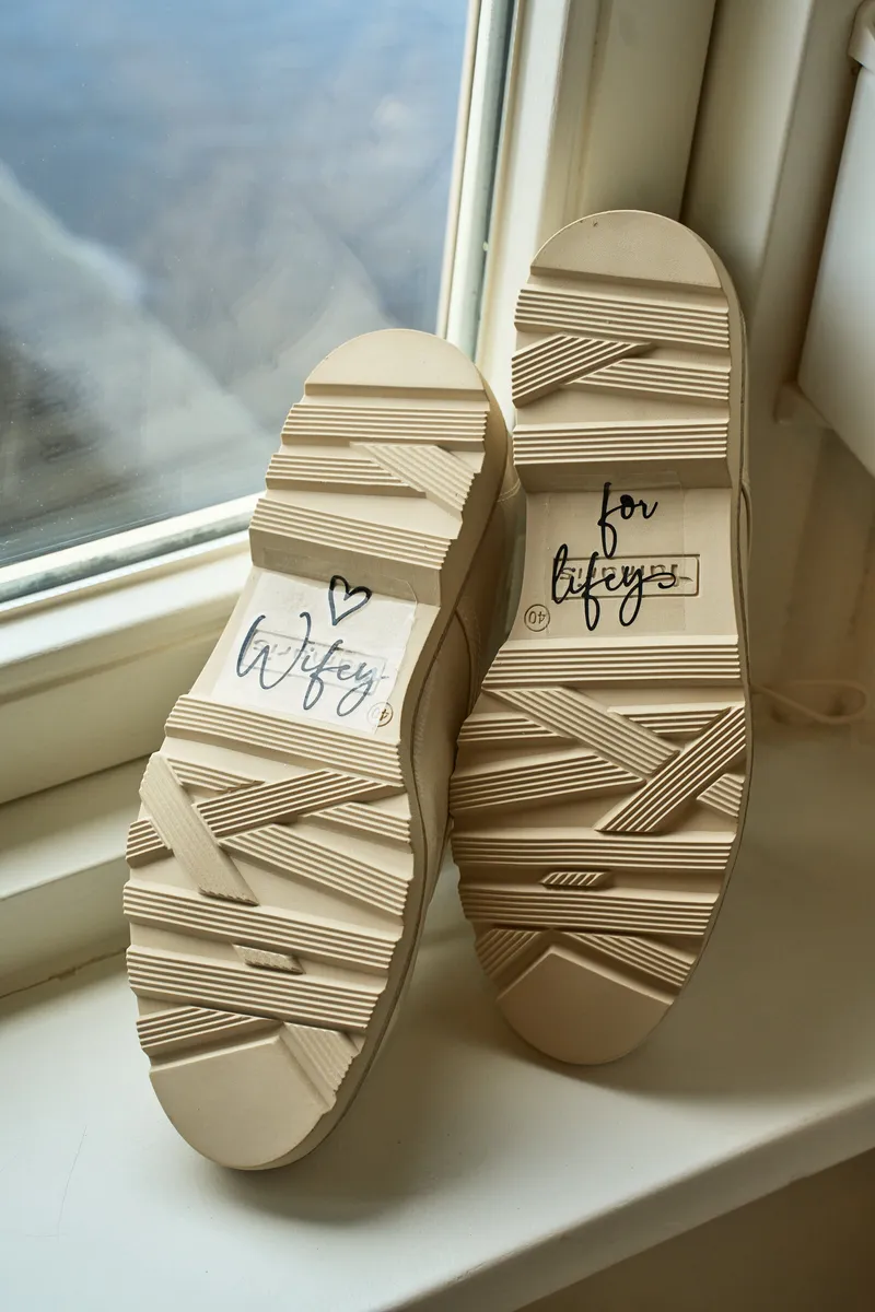 De trouwschoenen bij het raam, met tekst op de zolen