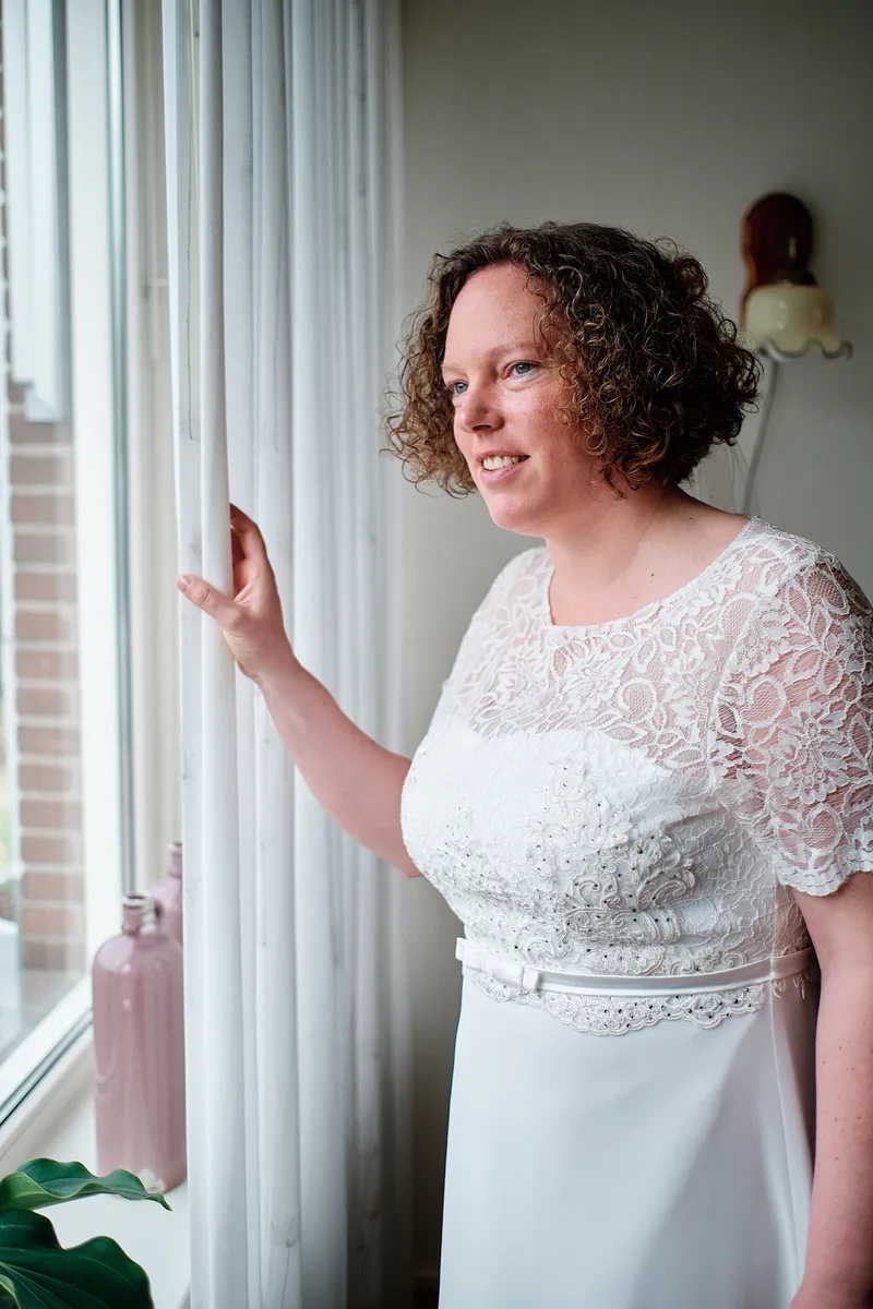 Janneke in haar jurk bij het raam