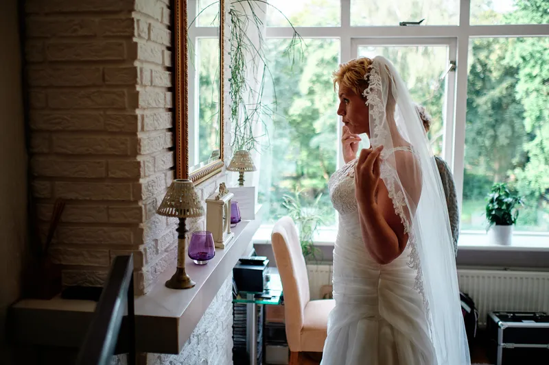 Helen in haar jurk met sluier bij de haard