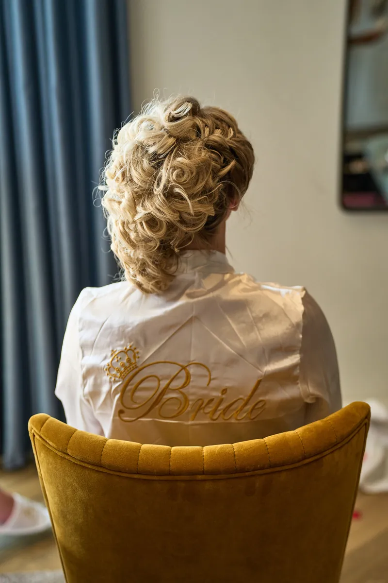De bruid in haar badjas met Bride op de rug