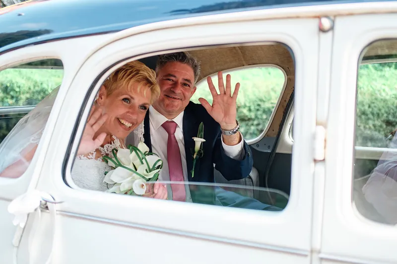 Helen en Burt zwaaien uit de witte Citroën