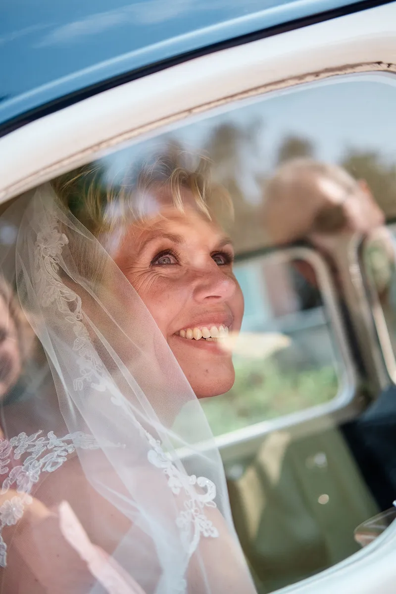 Helen lacht door het raam van de auto