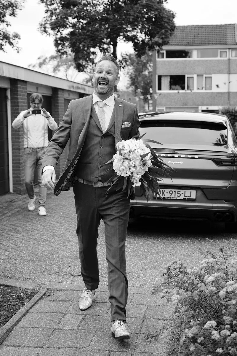 Eric komt met het boeket over de oprit aanlopen