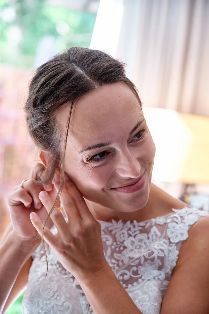Tessa glimlacht terwijl ze haar oorbel indoet