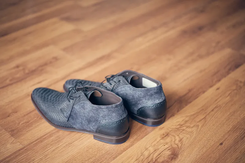 De nette schoenen van Herre op de houten vloer