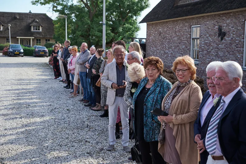 De gasten staan in een lange rij op het grind voor ’t Hof van Hoenkoop
