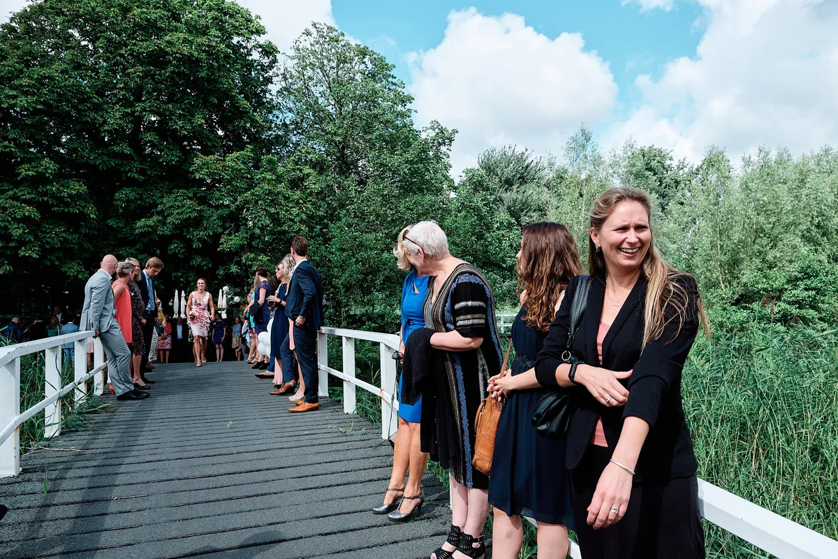 Gasten wachten op de witte brug van Het Rieten Dak