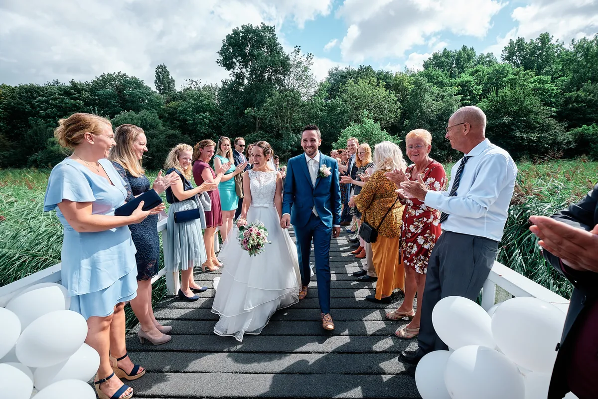 Tessa en Jeroen lopen over de brug tussen de gasten door