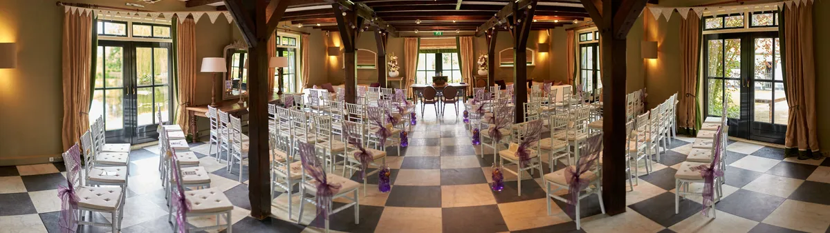 De zaal met gedekte tafels onder de houten balken