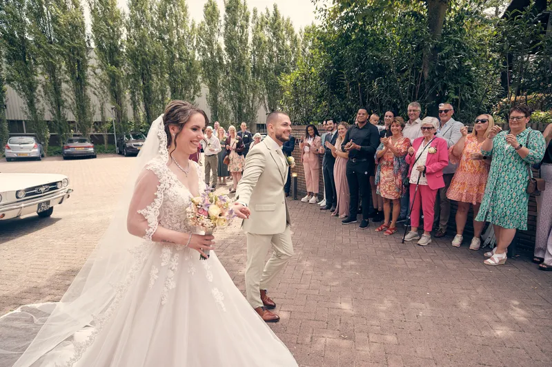 Wendy loopt met Robin langs de gasten, haar lange sluier achter zich aan