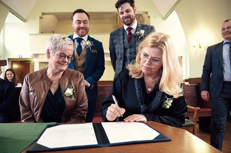 Twee getuigen tekenen, het paar staat erachter