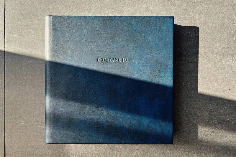 Een blauw leren trouwalbum in het zonlicht