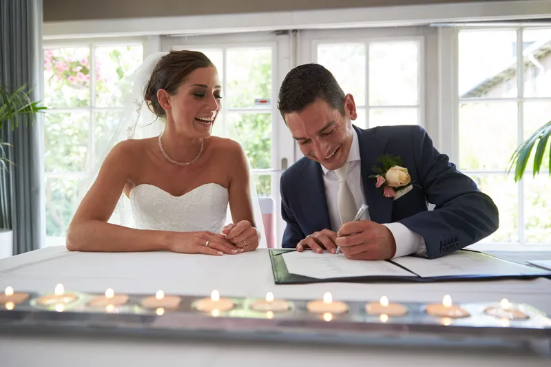 Sanne en Patrick tekenen de trouwakte