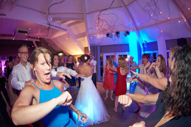 Gasten dansen in blauw licht