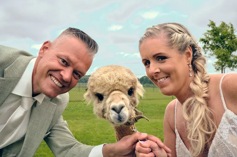 Marco en Tamara met een alpaca tussen hun hoofden